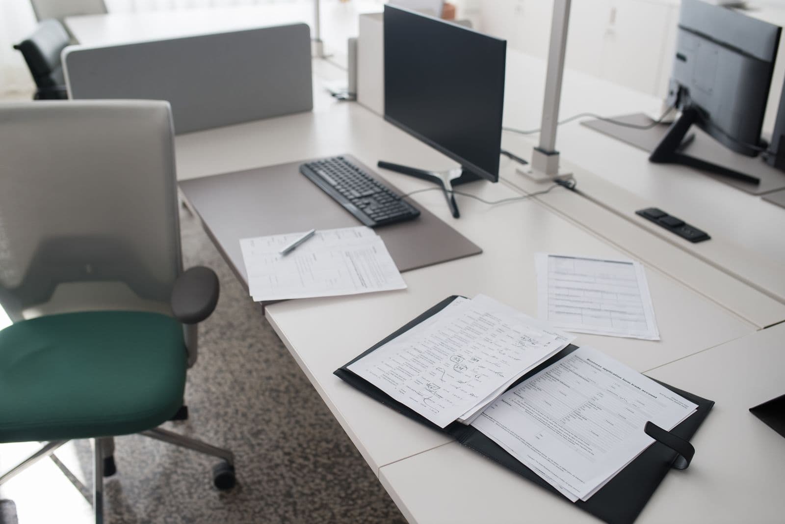 A binder of documents open on a tidy work desk.