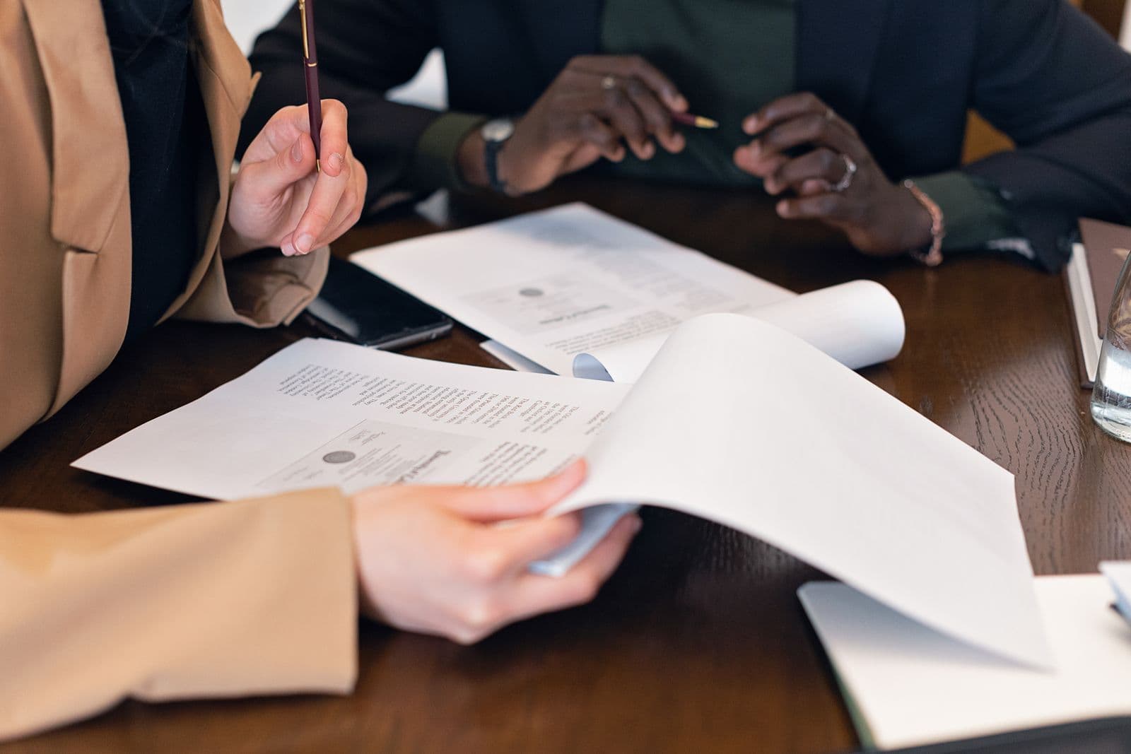 Two people reviewing printed documents together across a table.