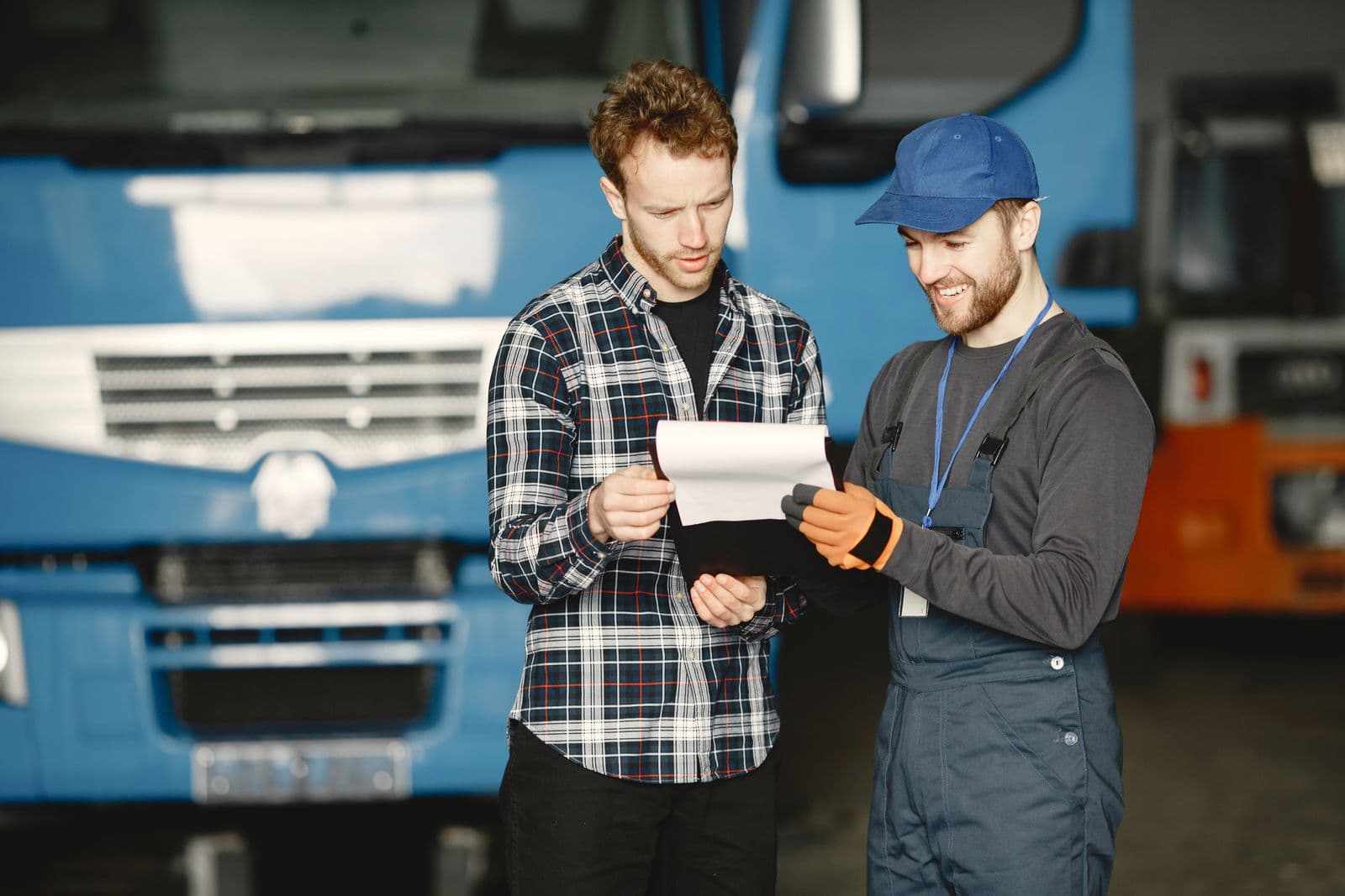 Two tradespeople going over paperwork together in a workshop.