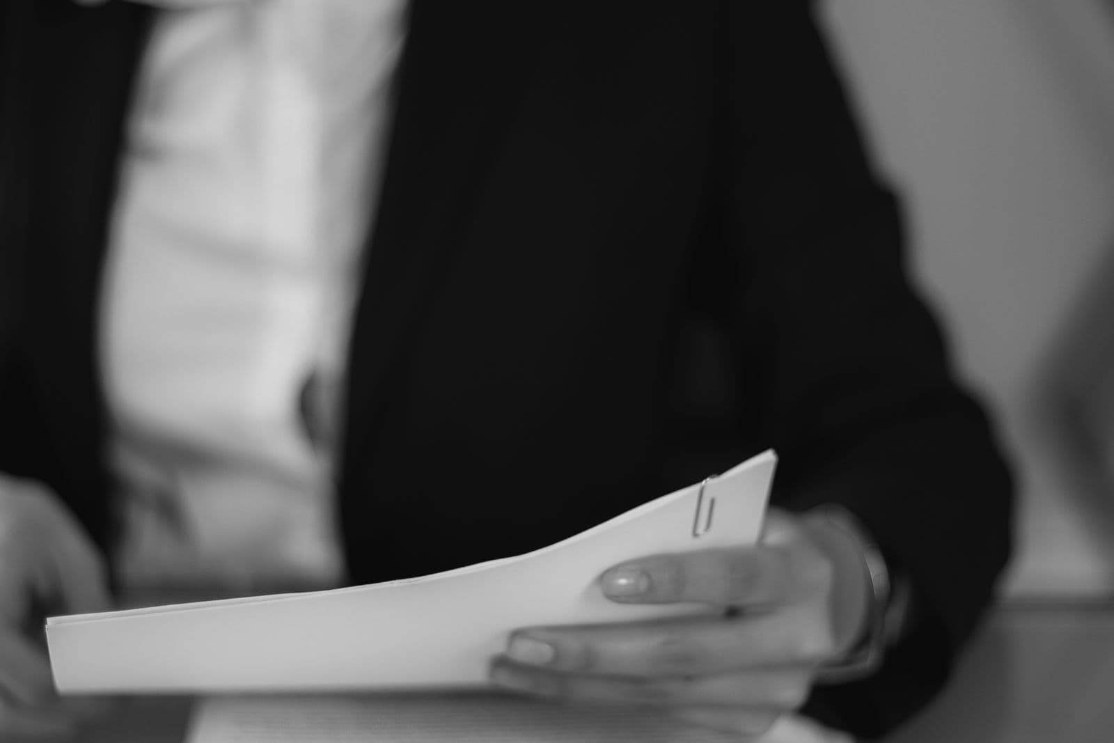 A person reading through a thick stack of documents.