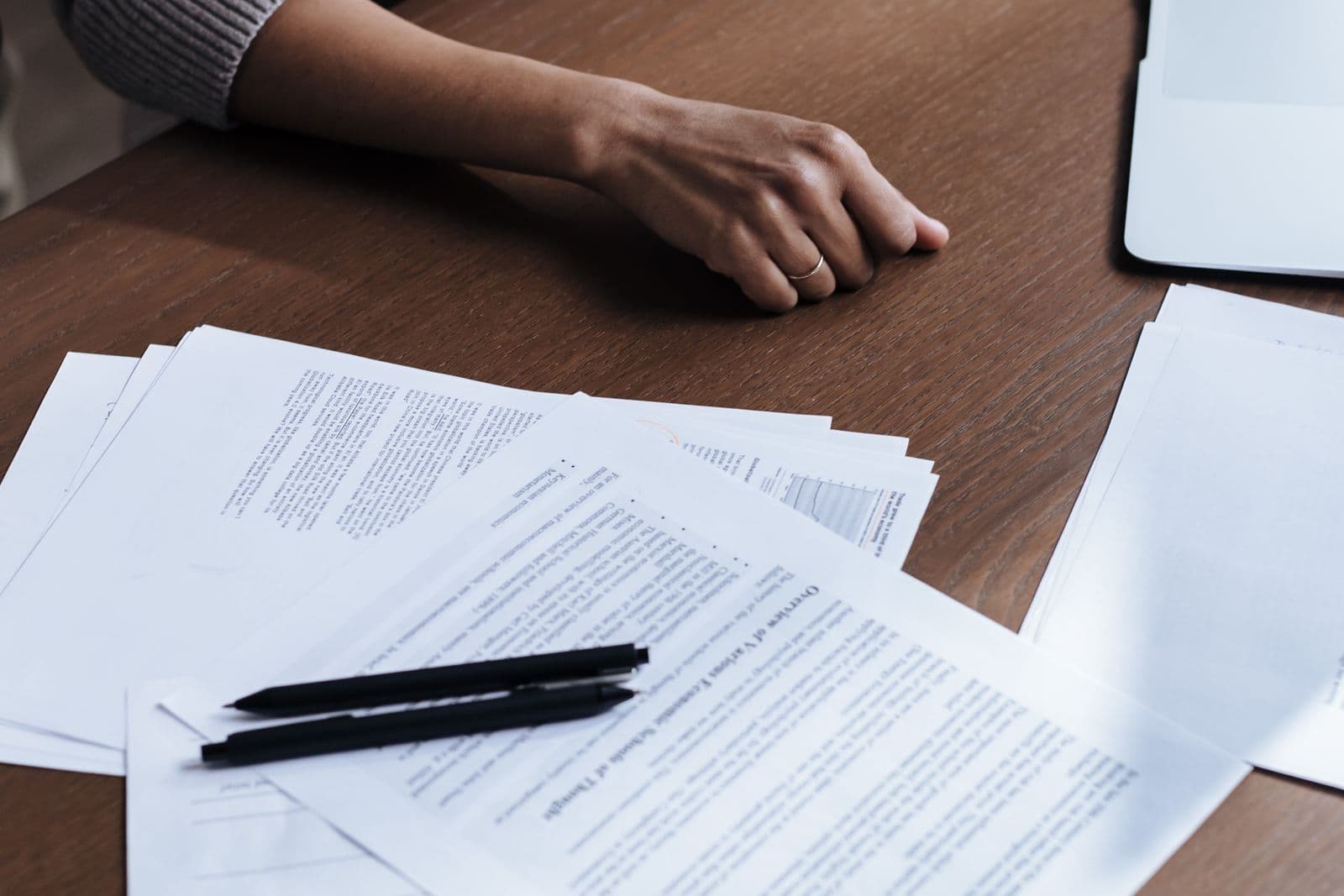 An overhead view of hands working through documents spread across a desk.